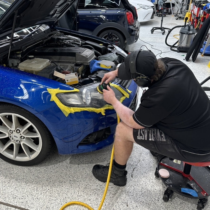 headlight restoration in a detailing workshop