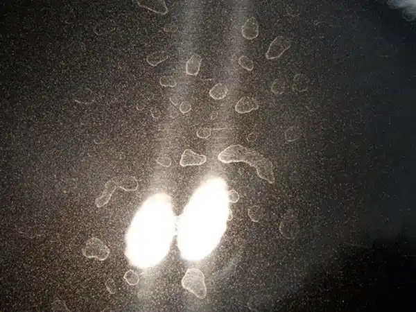 A close up of a vehicle with water spots